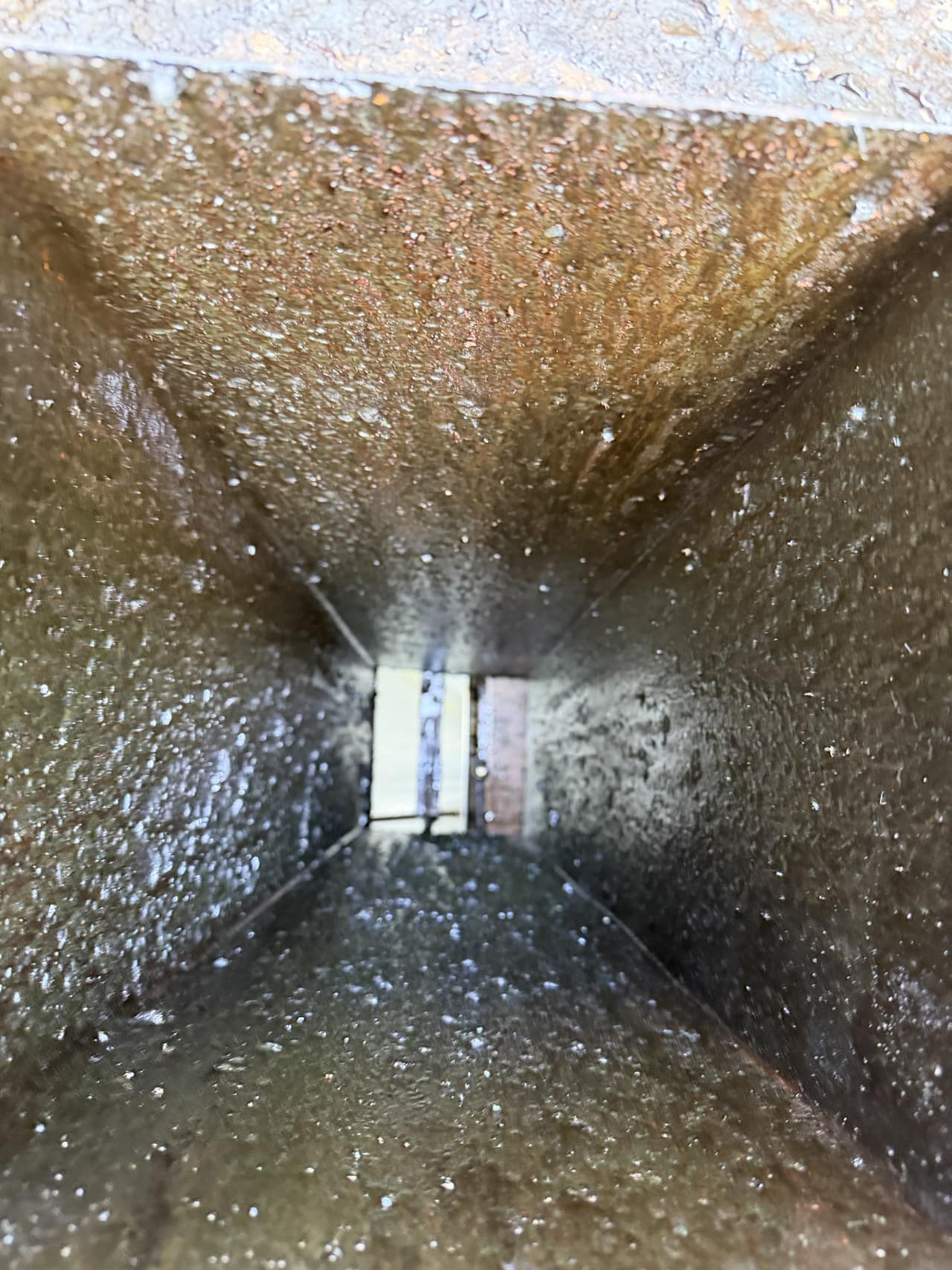 The interior of a restaurant kitchen exhaust duct photographed during cleaning service.