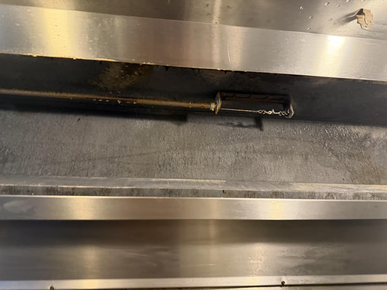 The plenum and stainless-steel lips of the barbecue kitchen's exhaust hood after cleaning, with the grease runs gone from the lip.